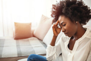 woman holding her head in pain